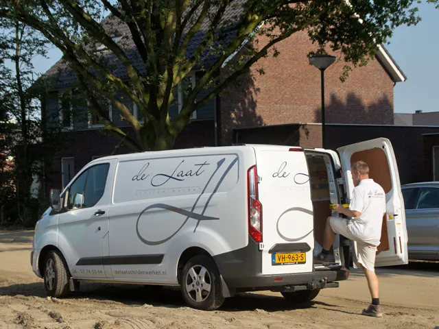 Bedrijfsbus van De Laat Schilderwerken voor een woning